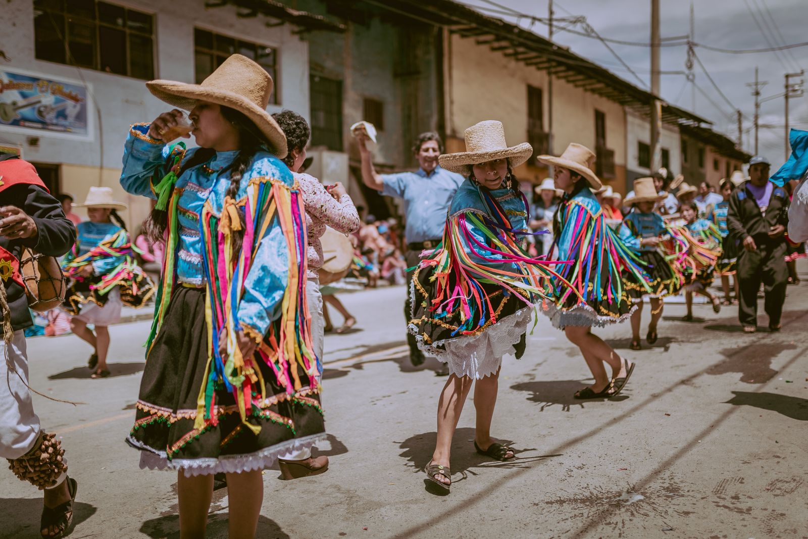Danzantes con sombrero y trajes de colores bailan en una calle de Cajamarca durante un desfile