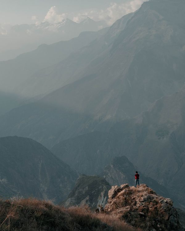 Man Standing on a Mountain Looking Out · Free Stock Photo