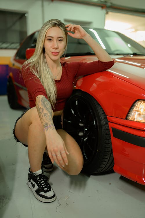 Young Woman Posing next to a Red BMW E36 in the Garage 