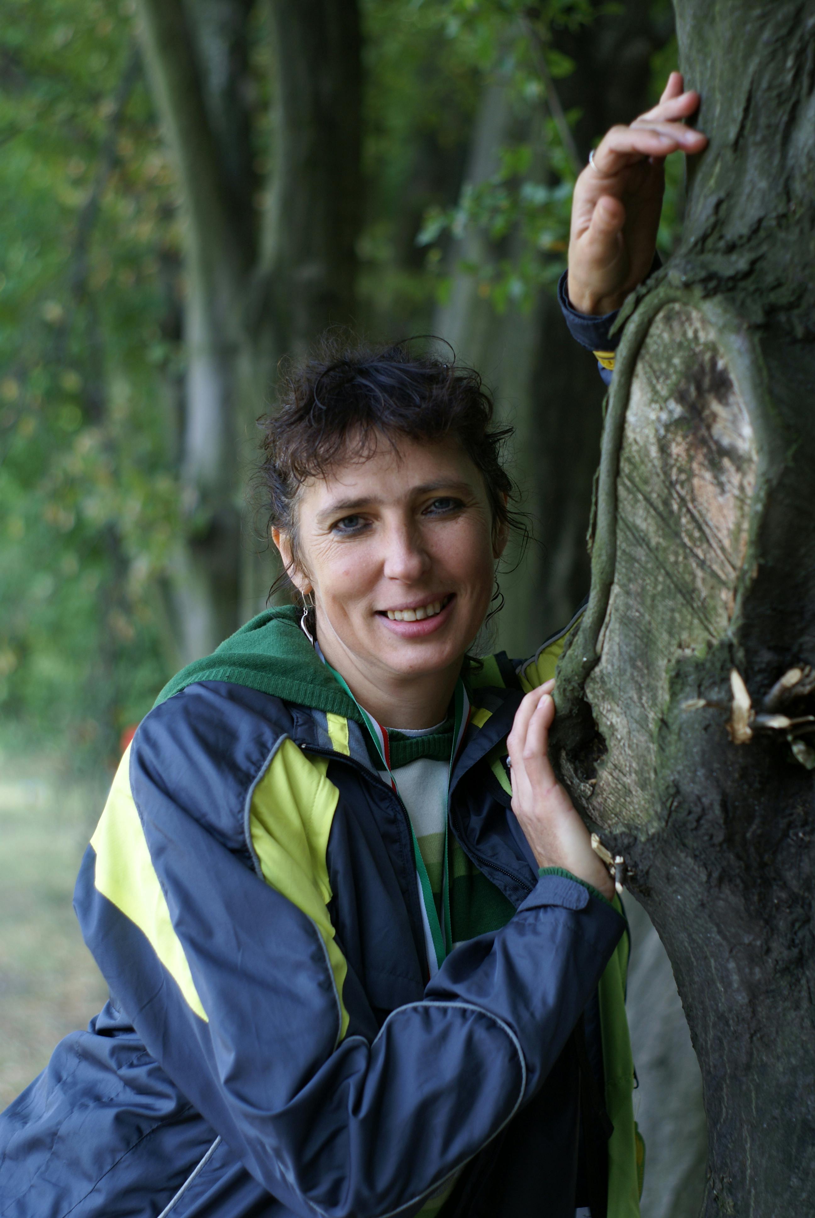 a woman leaning against a tree in a forest