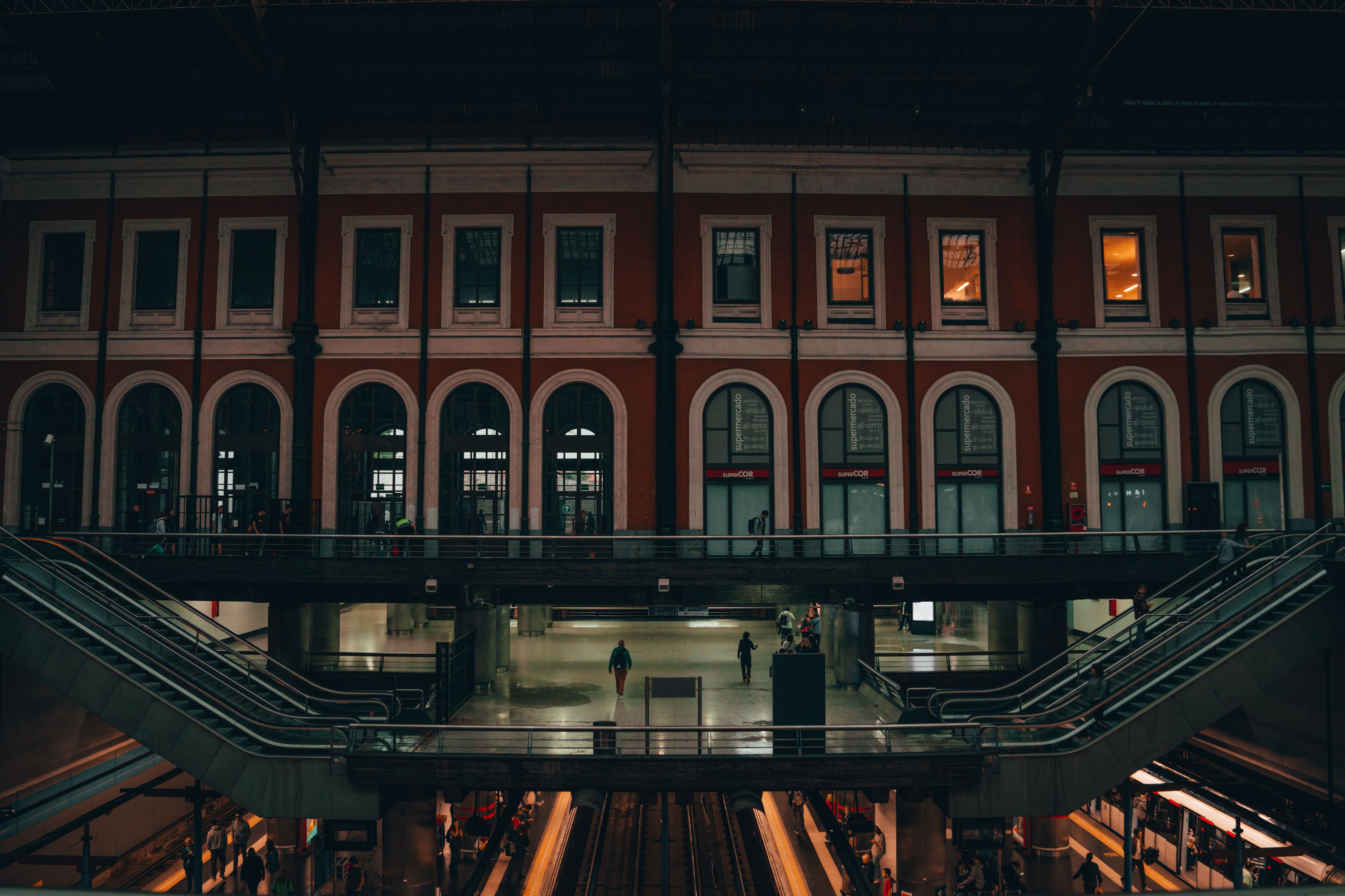 A view of Príncipe Pío train station in Madrid, showcasing its architectural design and evening ambiance. A view of Príncipe Pío train station in Madrid, showcasing its architectural design and evening ambiance.