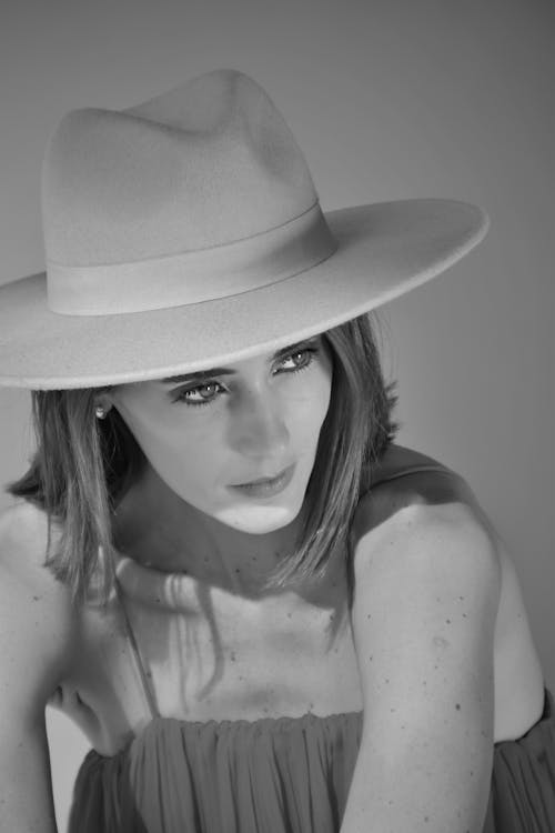 Black and White Studio Shot of a Young Woman in a Dress and Hat 