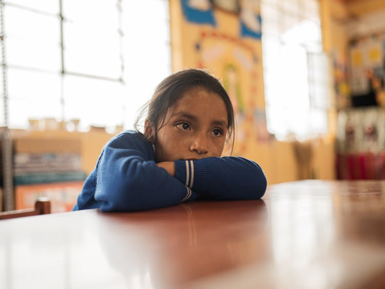 Young Girl Sitting In A Classroom 