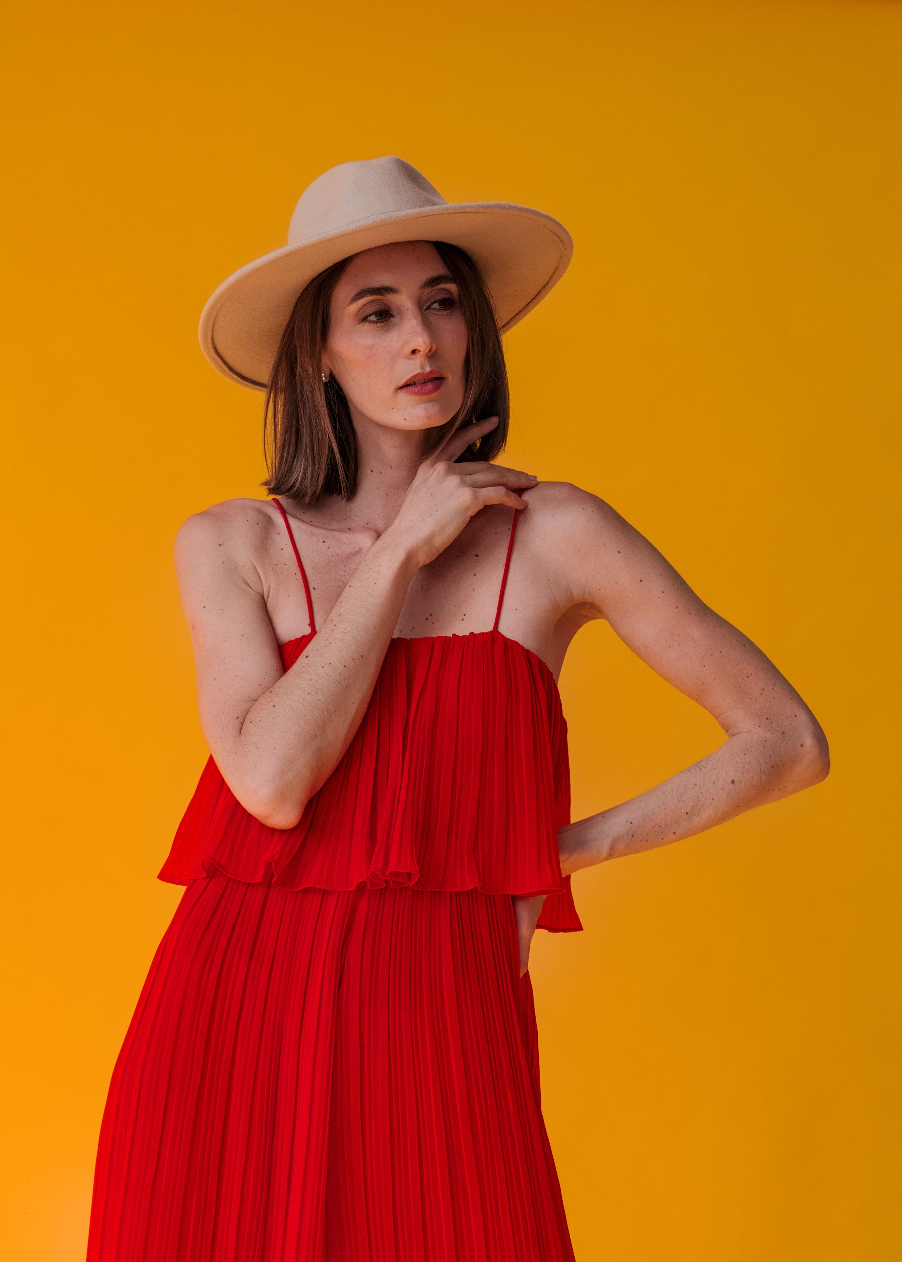 Young Woman in a Red Dress and a Hat Posing in Studio · Free Stock Photo