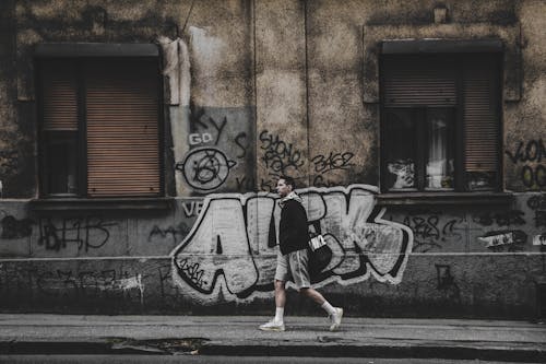 Man in Jacket Walking on Sidewalk