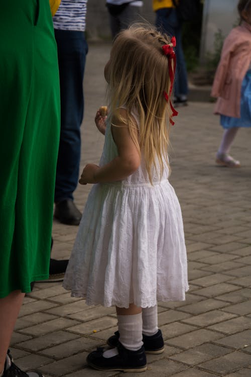 Free Little Blonde Girl Wearing White Dress on a Pavement  Stock Photo