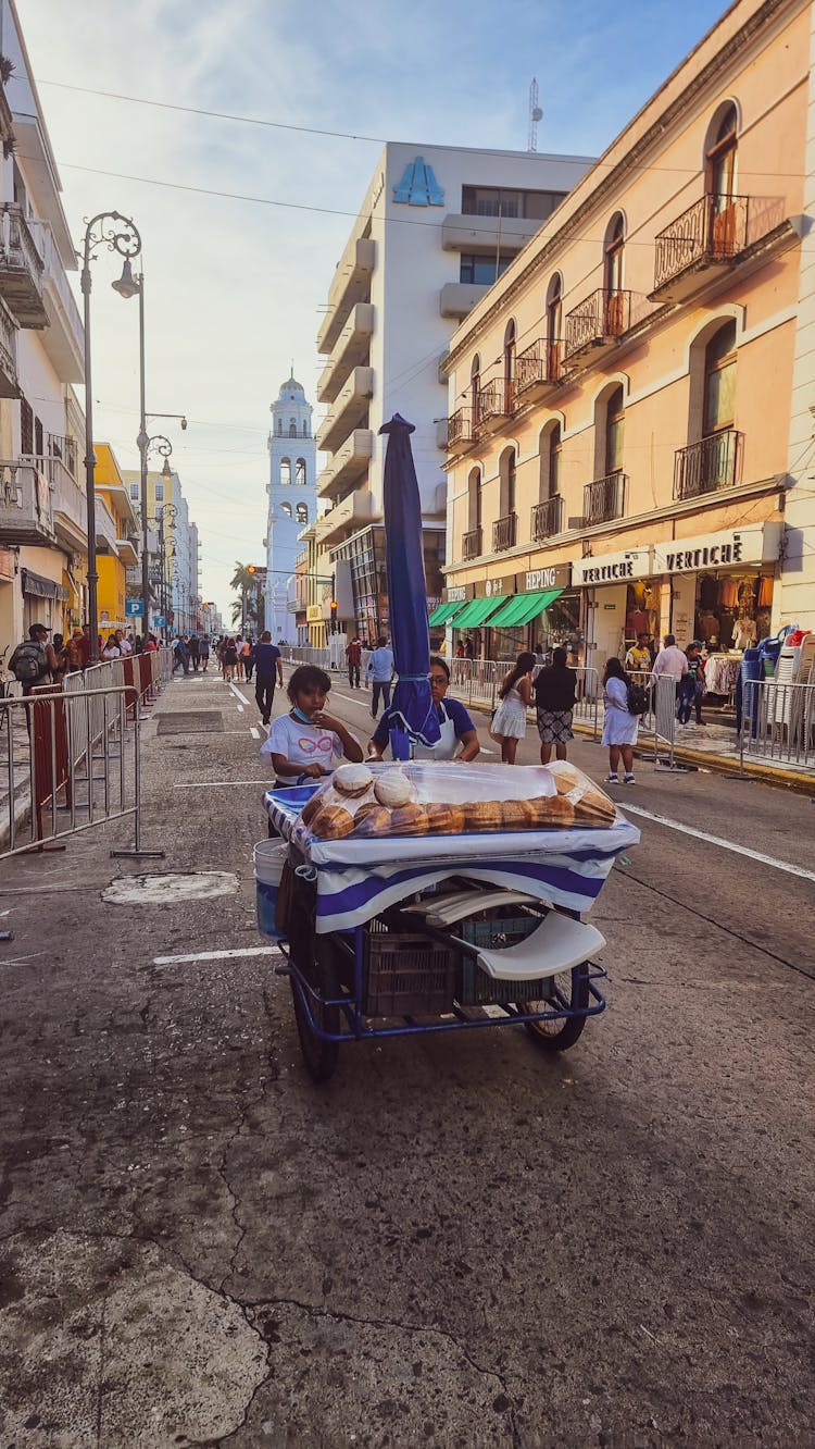 Women Pushing Cart With Bread On Street