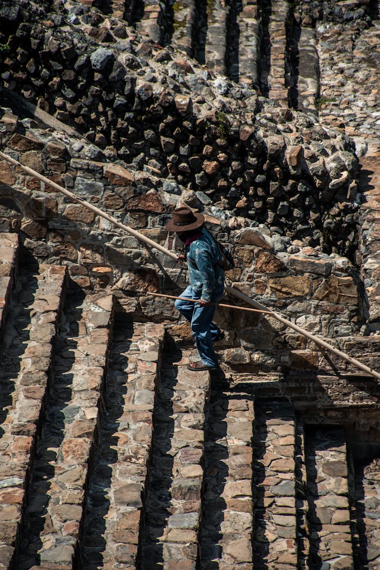 Man Walking Upstairs In Ancient Ruins