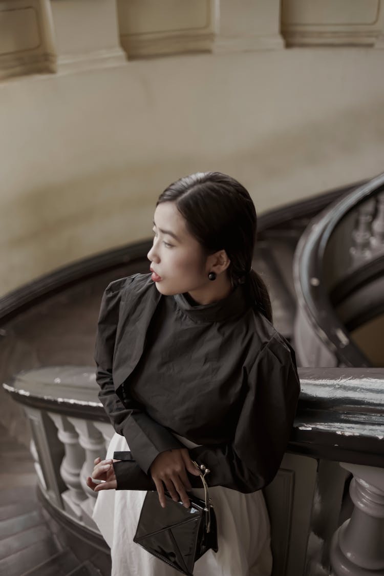 An Elegant Woman Standing On Spiral Steps 