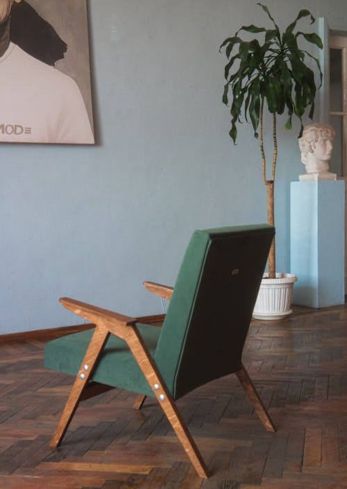 A Green Vintage Armchair Standing on a Wooden Floor 