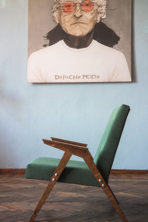 A Green Vintage Armchair Standing on a Wooden Floor 