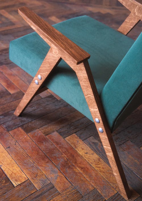 A Green Vintage Armchair Standing on a Wooden Floor 