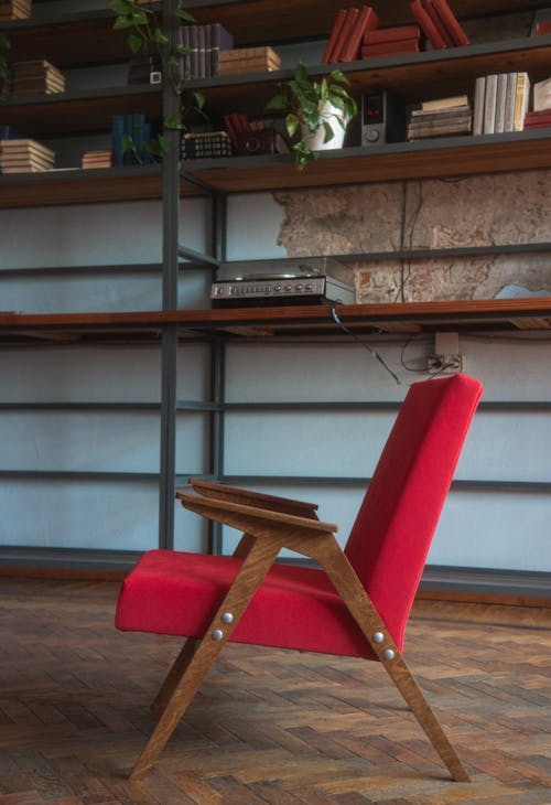 A Red Vintage Armchair Standing on a Wooden Floor 