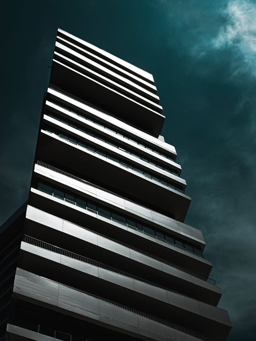 Free A towering modern skyscraper in Istanbul against a backdrop of dramatic dark clouds, showcasing contemporary architectural design. Stock Photo