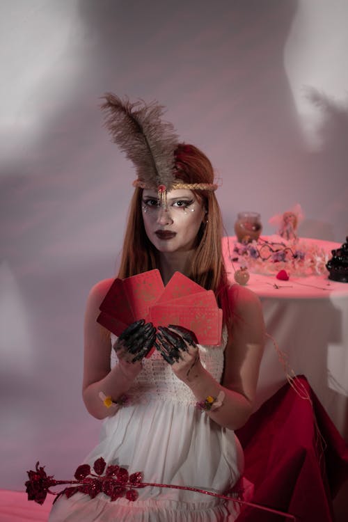 Woman Holding Red Cards in a Studio 