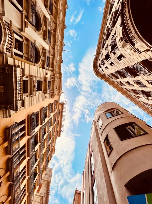 Free Vibrant capture of urban architecture and blue sky, shot from street level looking upwards Stock Photo