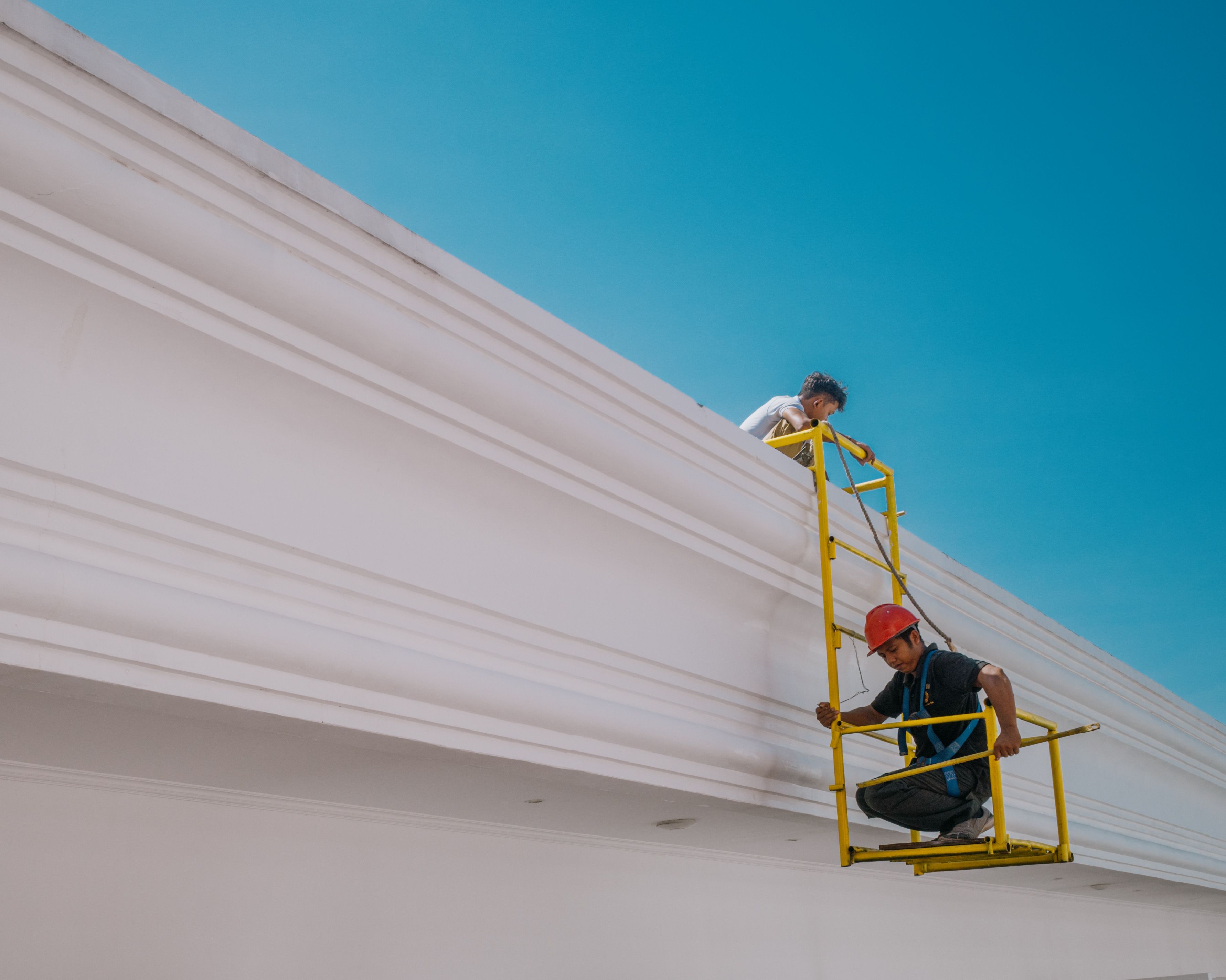professional painting crew working on a house - paint outside of house