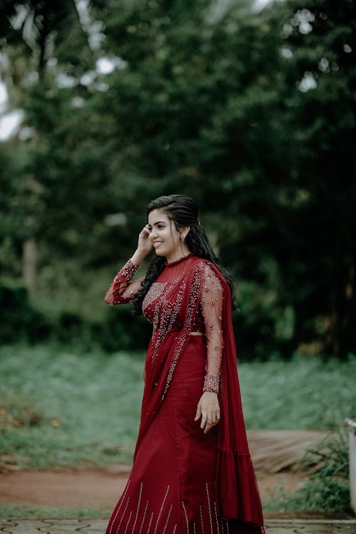 Young Woman in an Elegant Red Saree Dress Standing Outdoors