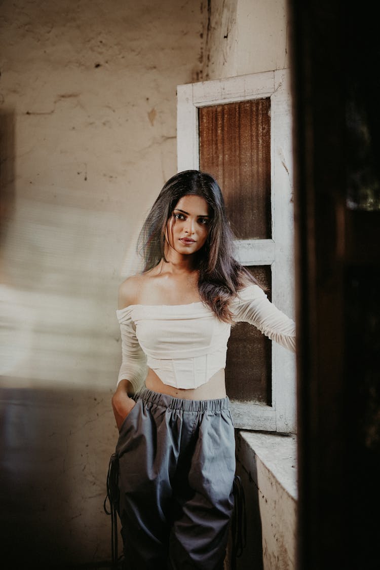 Young Brunette Standing By The Window In An Abandoned House 