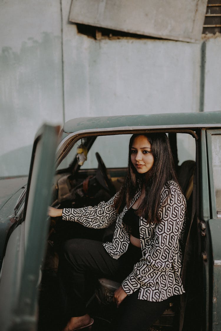 Young Woman Sitting In An Old Car