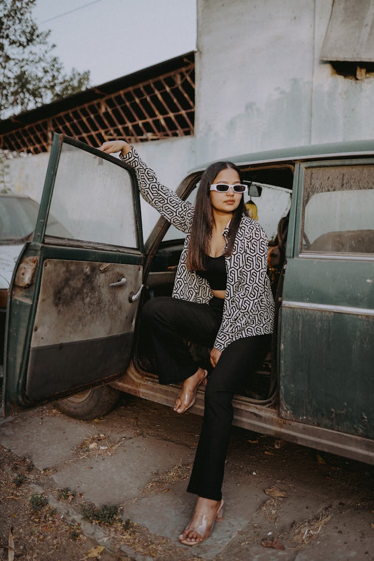 Young Woman Getting Out Of An Old Car