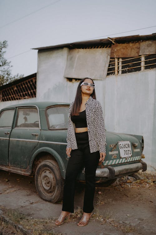 Woman in Sunglasses Standing and Posing near Vintage Car