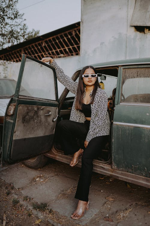 Woman in Sunglasses Sitting and Posing in Vintage Car