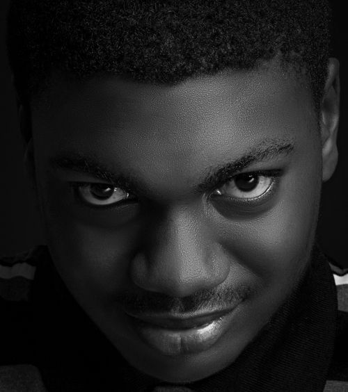 Free Close-up headshot of a smiling teenage boy looking up in black and white. Stock Photo