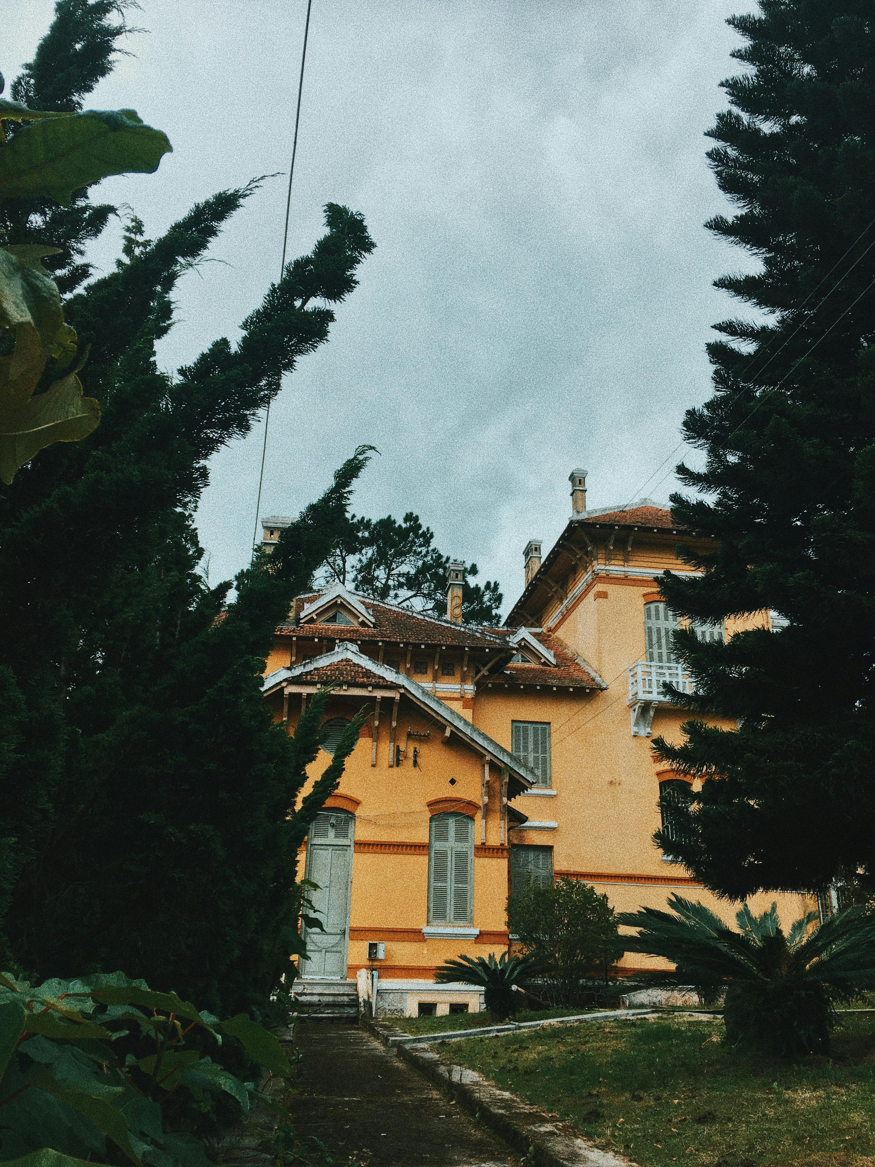 beige painted house near green trees