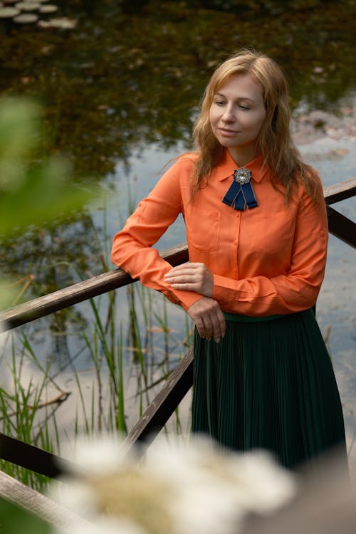 Woman in Orange Shirt Posing with Eyes Closed