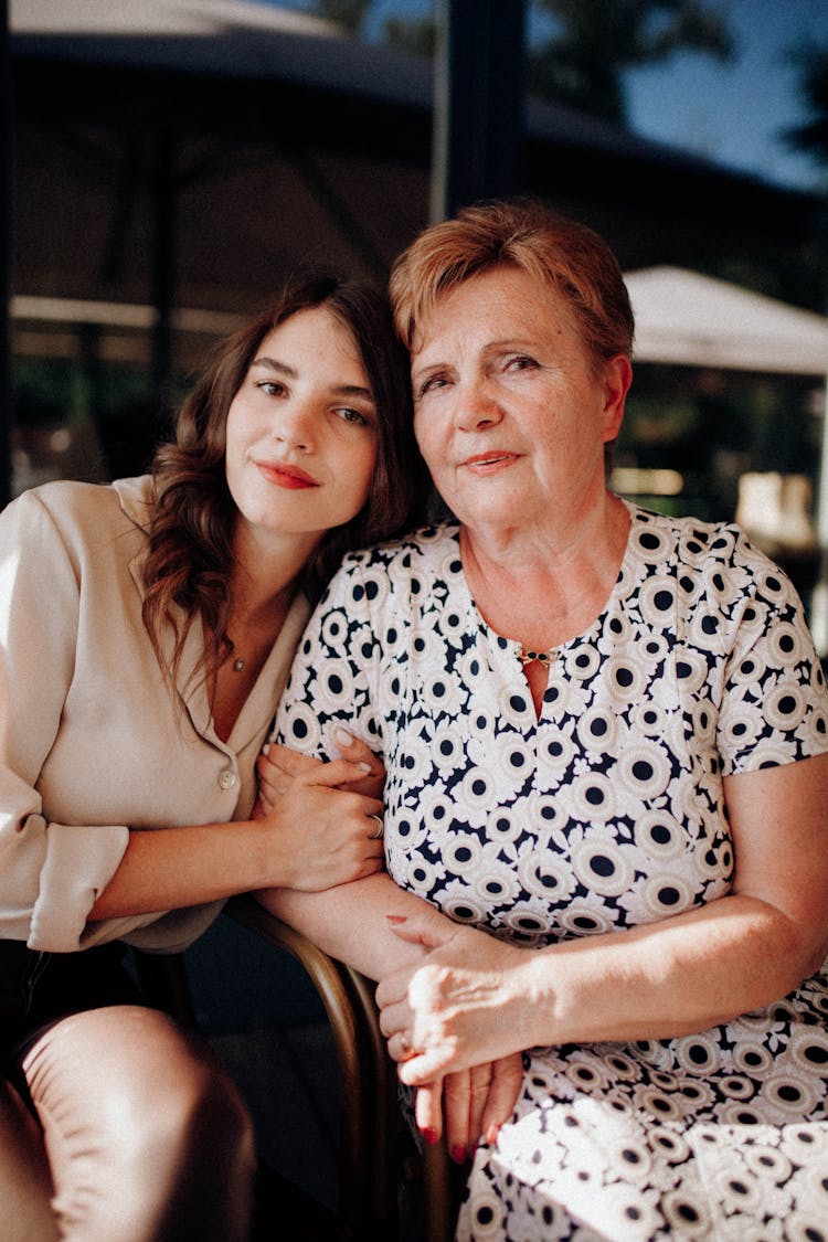 Mother And Daughter Sitting Close To Each Other 