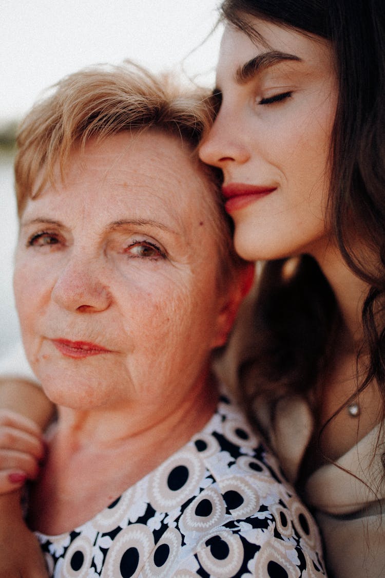 Mother And Daughter Standing Close To Each Other 