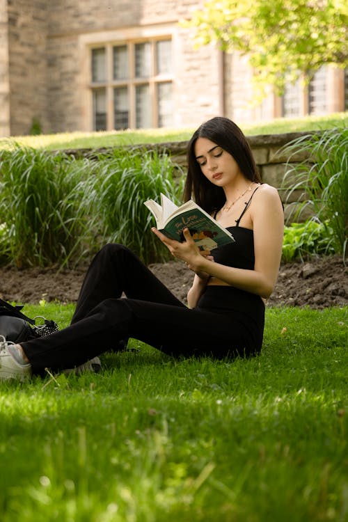 Woman in Black Clothes Sitting and Posing with Book