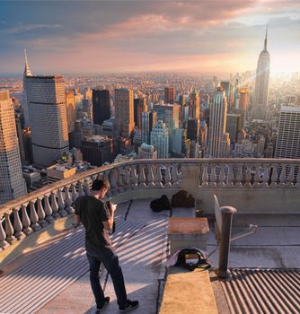 A man stands on a rooftop terrace, overlooking a vast cityscape at sunset with iconic skyscrapers.