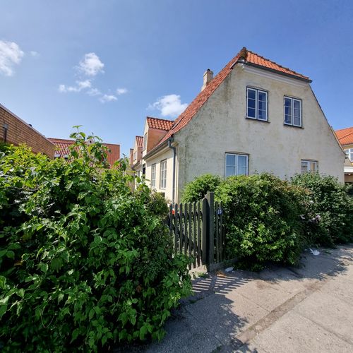 Free A scenic view of a traditional village house with vibrant greenery on a sunny day. Stock Photo