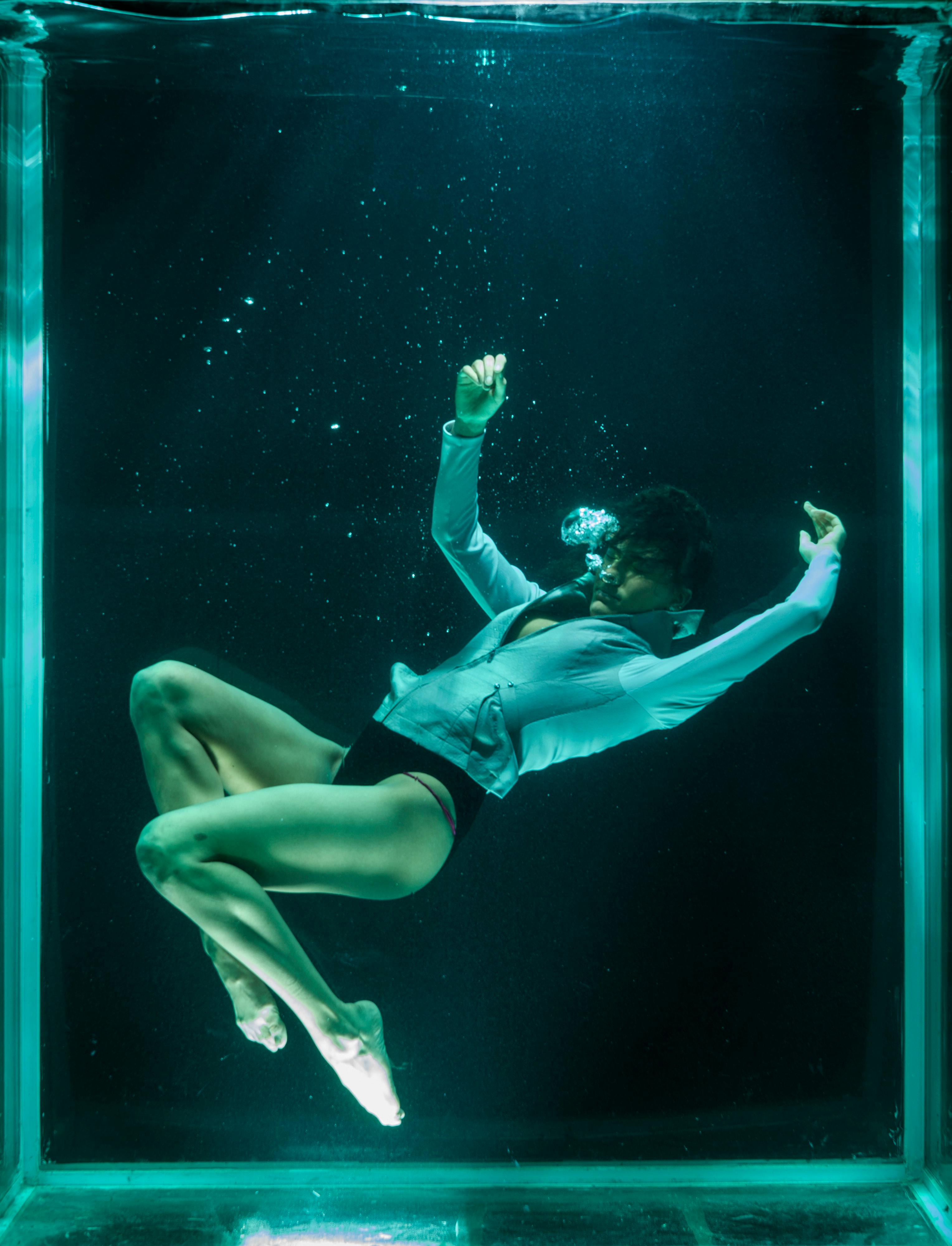 person wearing white long sleeved shirt in underwater