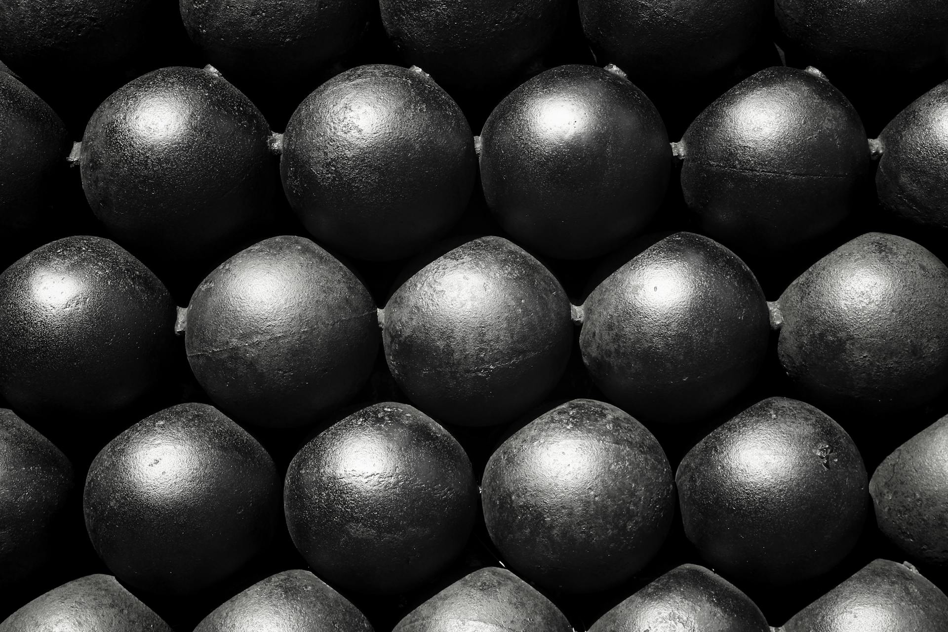 Close-up of black spheres arranged in symmetrical rows, creating a striking geometric pattern.