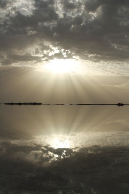 View of a Bright Sun Reflecting in a Body of Water 