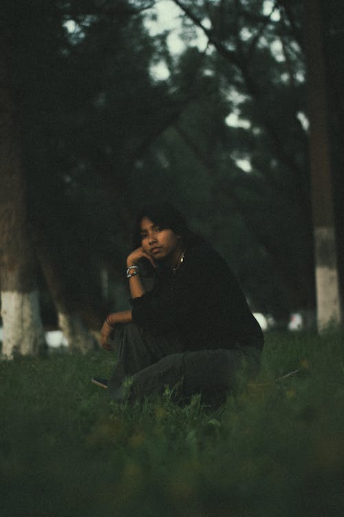 Man Squatting and Posing among Trees