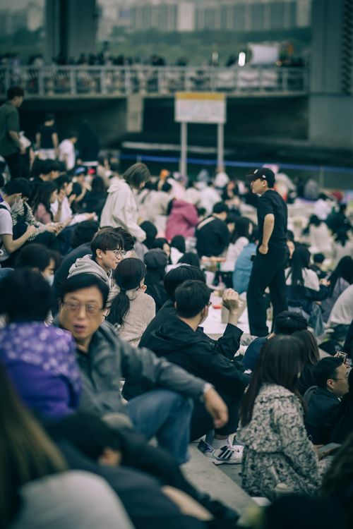 Free An outdoor gathering of diverse individuals in Seoul, showcasing urban life and culture. Stock Photo