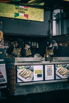 Street vendors cooking Mexican food at an urban food stall, showcasing delicious tacos.
