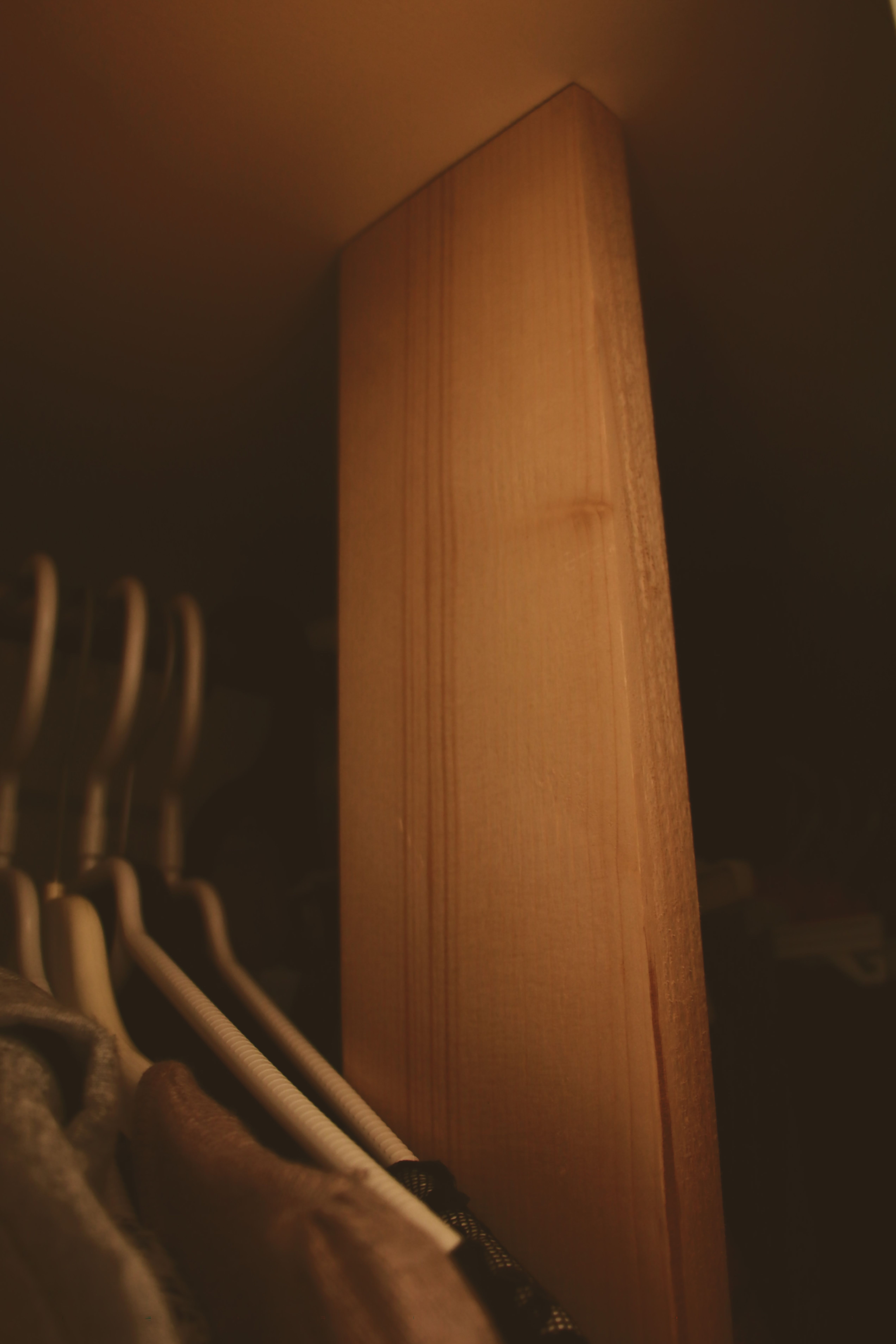 Wooden wardrobe interior with hangers creating a minimalist aesthetic.