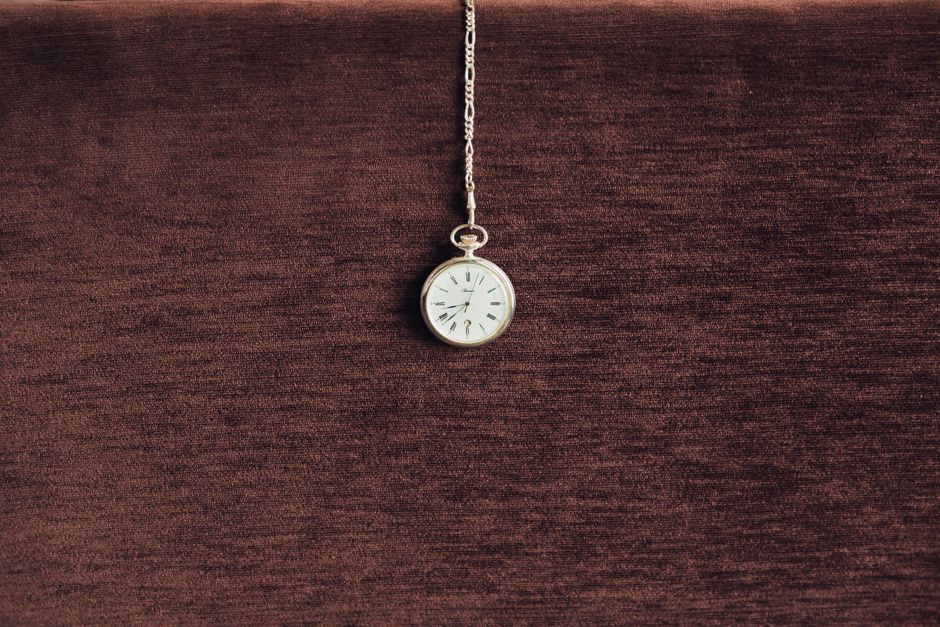 Sophisticated vintage pocket watch with chain against a rich velvet background, highlighting elegance and timelessness.