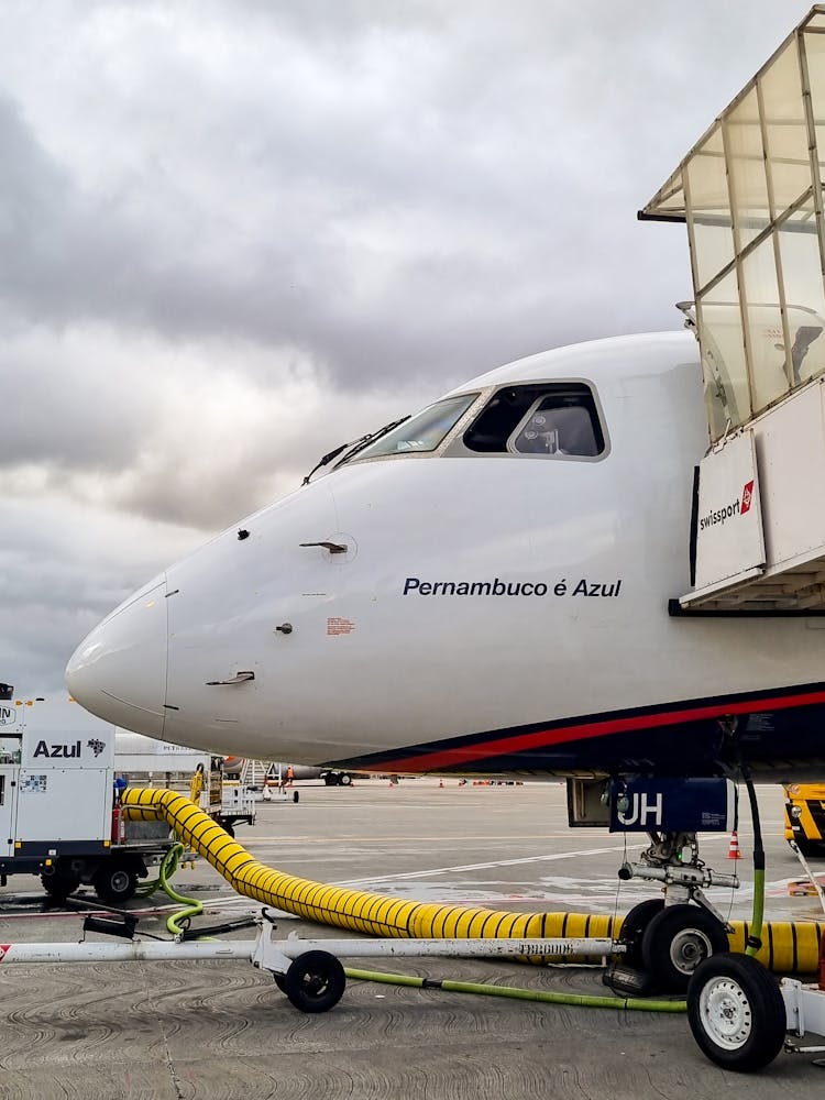 Passenger Jet Plane Parked By Airport Terminal While Boarding