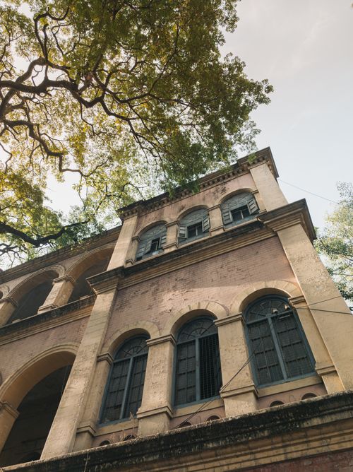 Free Explore historic architecture with arched windows surrounded by lush trees in Bengaluru, India. Stock Photo