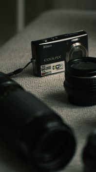 Close-up of a Nikon COOLPIX camera with lenses on a fabric background, emphasizing photography equipment.