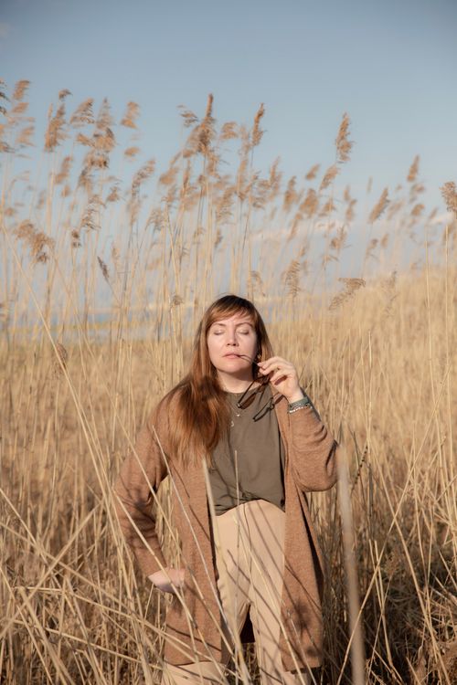 Free Woman posing in a serene wheat field under bright sunlight, capturing a summer's day in a rural setting. Stock Photo