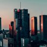 Modern financial skyscrapers in Warsaw, Poland reflect the warm light of sunset.