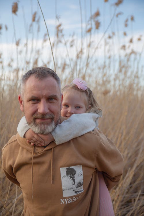 Portrait of Father Holding Daughter · Free Stock Photo