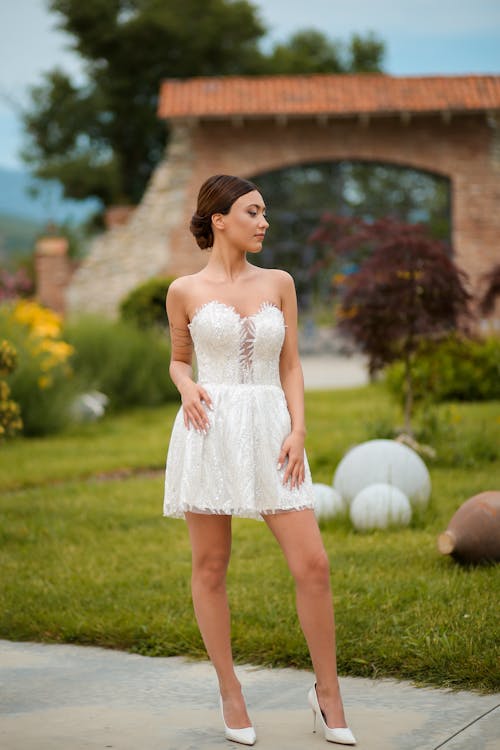 Woman Posing in White Short Dress and High Heels